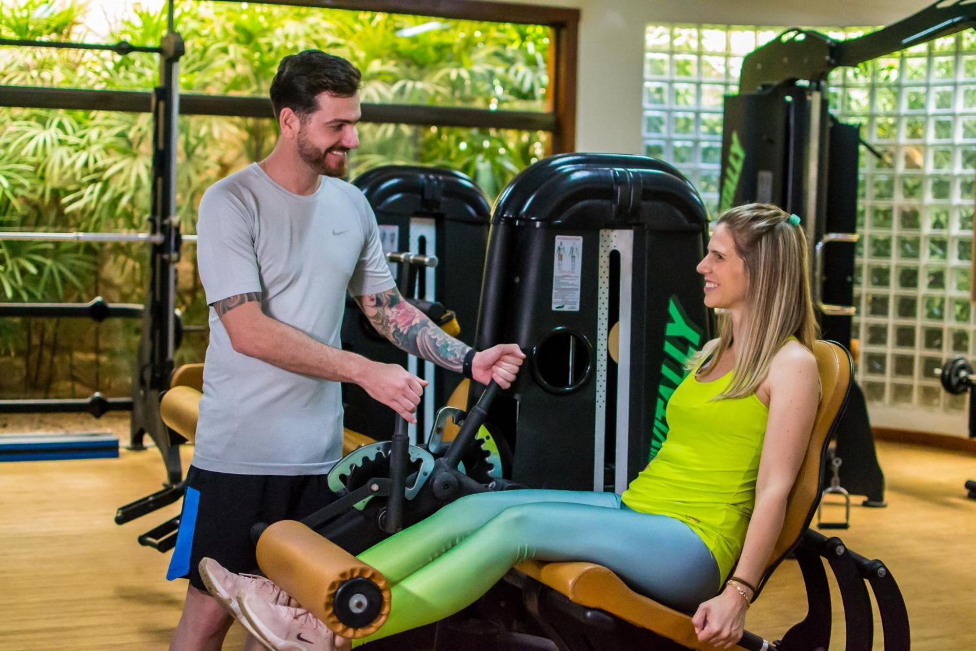 Blue Tree Thermas De Lins Resort Eksteriør bilde Personal trainer assisting a woman on a leg press machine